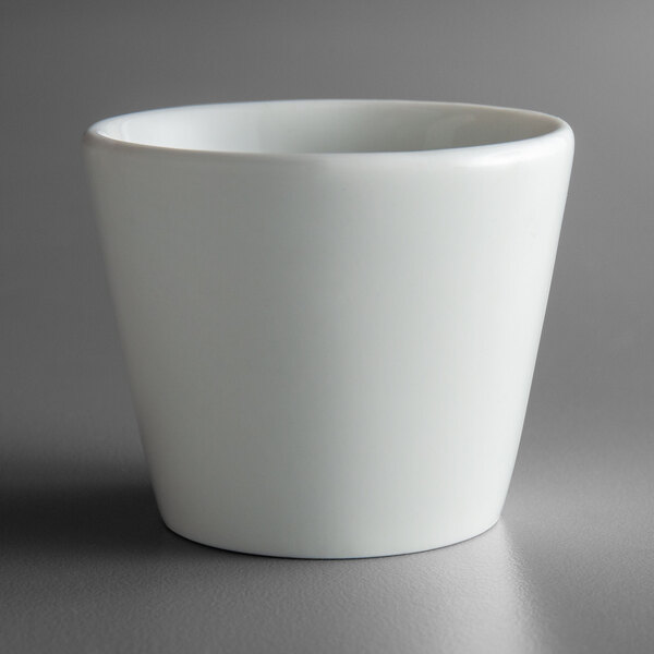 A Schonwald Allure bone white porcelain egg cup on a gray surface.