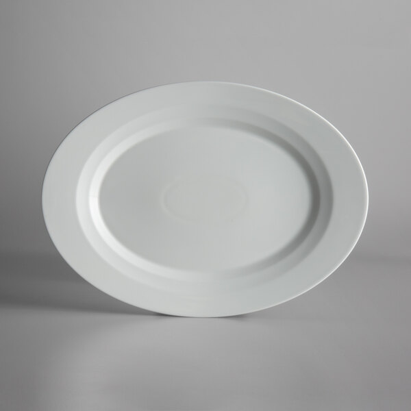 A white porcelain platter with a raised rim on a white surface.