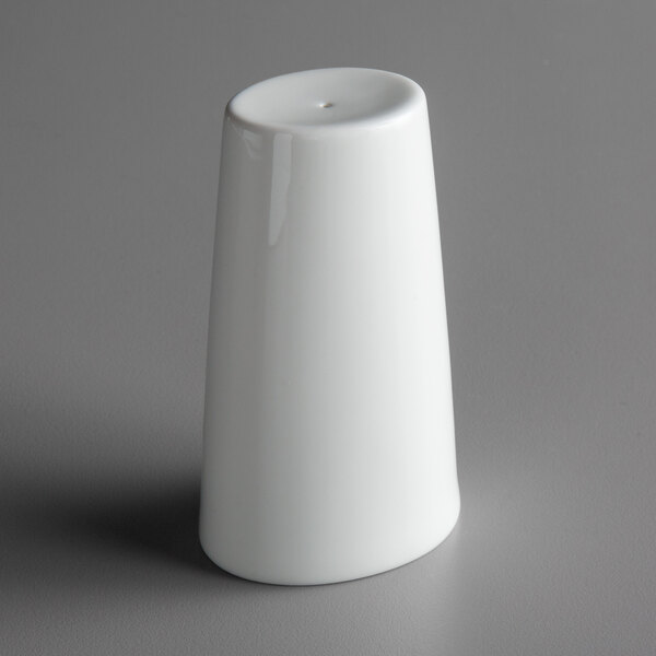 A Schonwald bone white porcelain salt shaker on a gray surface.