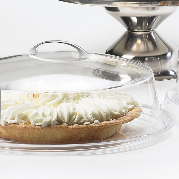A pie in a Cal-Mil acrylic cover on a counter.