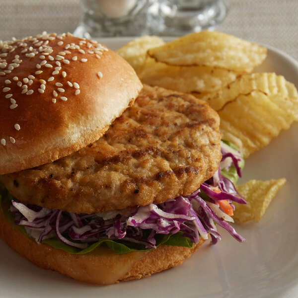 A plate with a Flame Grilled Chicken Burger and chips.