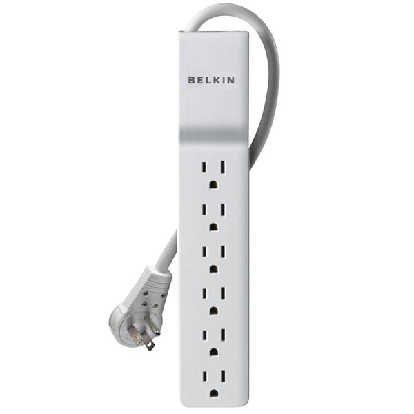 A close-up of a white Belkin surge protector with a rotating plug.