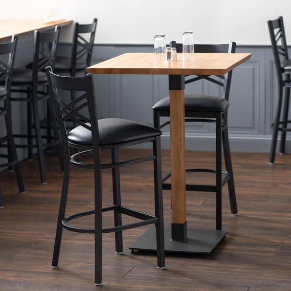 A Lancaster Table & Seating live edge bar table with an antique natural finish.