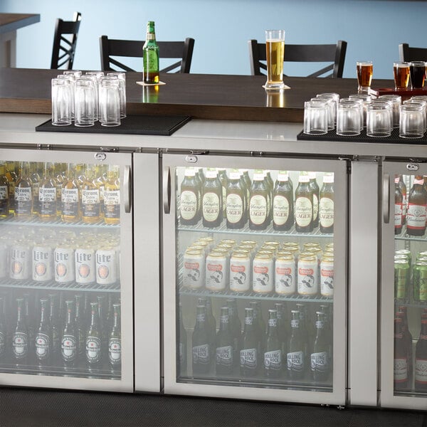 The glass doors of a stainless steel Avantco back bar refrigerator filled with beer bottles and glasses.