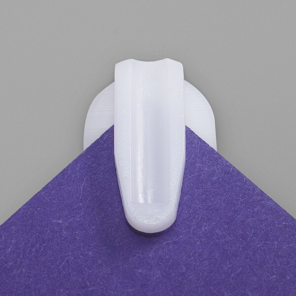 A close up of a white Advantus StikkiClip on a purple square.