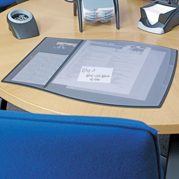 A Durable work pad on a table with a folder and paper in a binder.