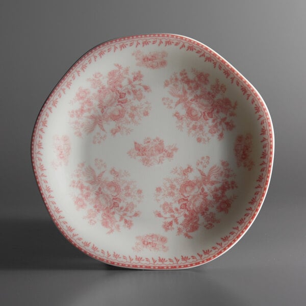 A close up of a pink Oneida Lancaster Garden porcelain plate with a floral design.