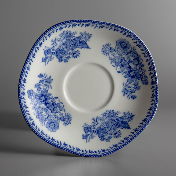 A white porcelain saucer with blue and white floral designs.