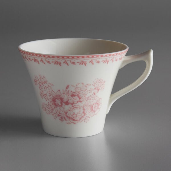 A white porcelain tea cup with a pink flower design.