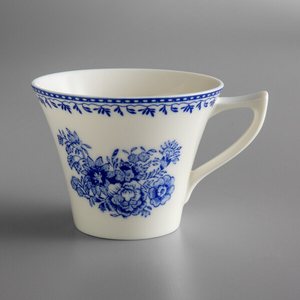 A white and blue teacup with blue flowers on it.