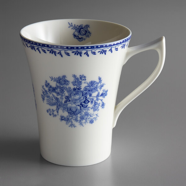 A white porcelain mug with a blue and white floral design.