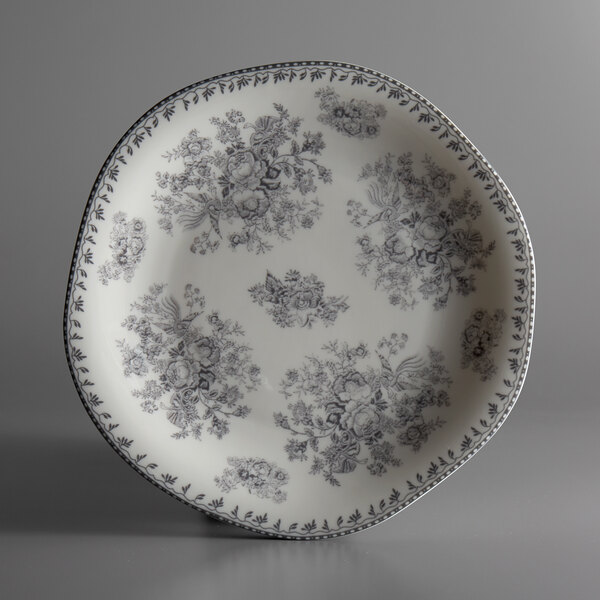 A white porcelain plate with a gray floral design.