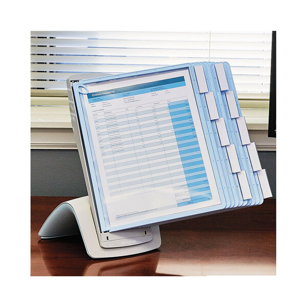 A blue and gray Durable Sherpa document folder on a desk with a computer monitor.