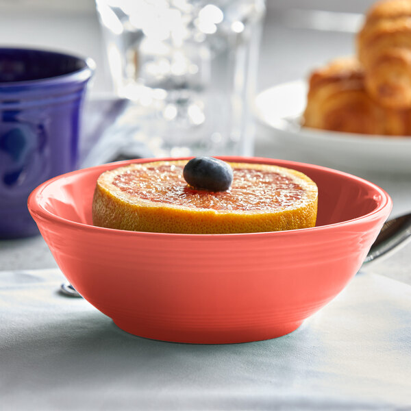 A Tuxton Cinnebar china nappie bowl filled with a grapefruit and orange slices.