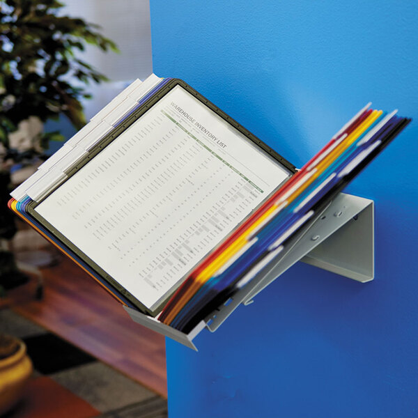 A Durable letter sized 20 panel desktop reference system with assorted borders and panels holding pages on a wall.