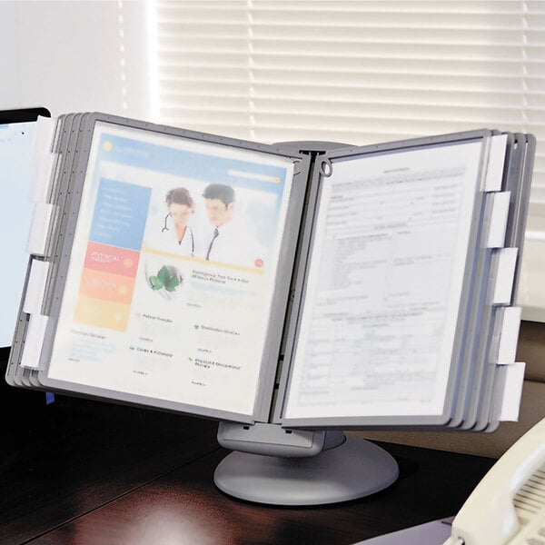 A Durable Sherpa desktop reference system on a desk with papers and a laptop.