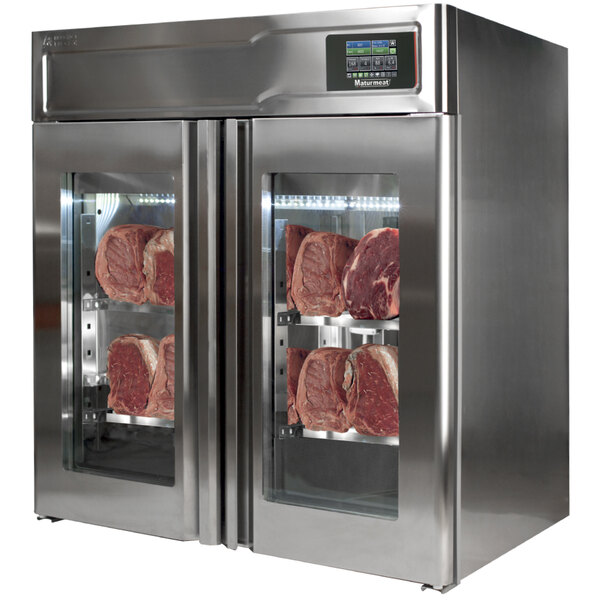 A stainless steel Maturmeat meat aging cabinet with glass doors full of meat.