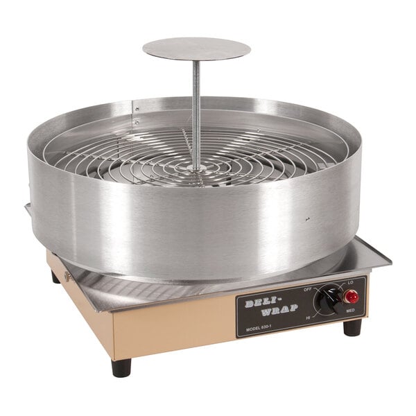 An Omcan deli pizza shrink wrapper machine with a round metal object.