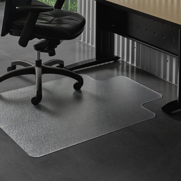 A black office chair on wheels on a clear ES Robbins chair mat on a desk.