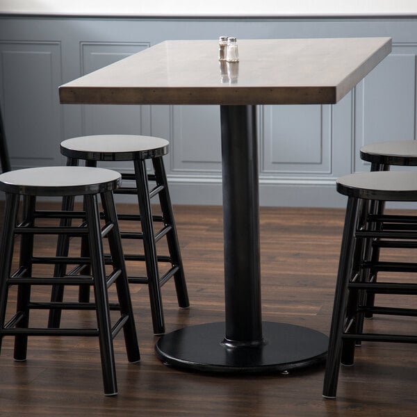A Lancaster Table & Seating black cast iron counter height table base with stools.