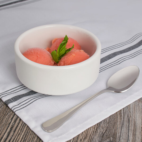 A bowl of pink ice cream with a Oneida Baguette stainless steel teaspoon.