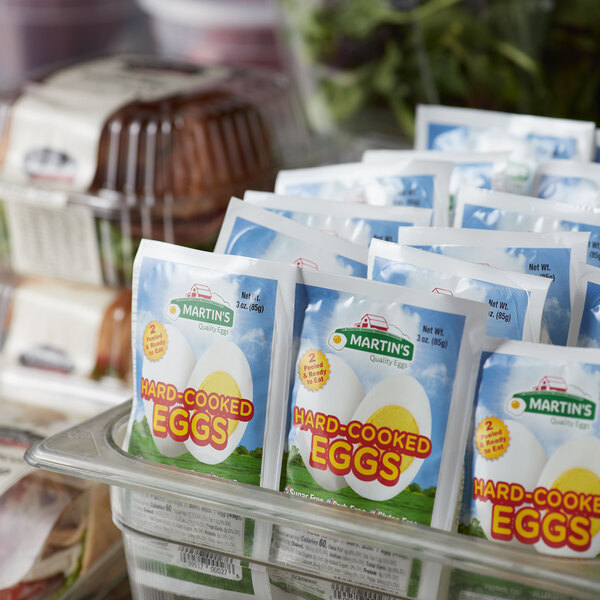 A plastic container with packages of Martin's Quality Hard Cooked Eggs.