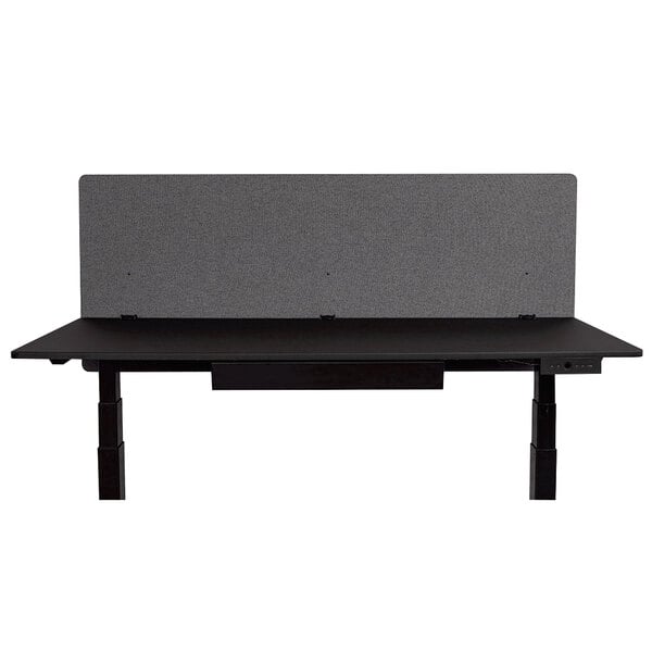 A black desk with a Luxor RECLAIM gray desk mount privacy panel.