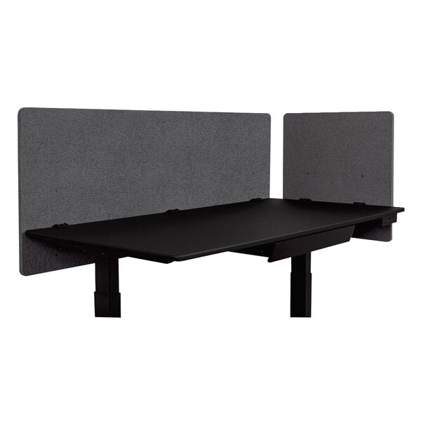 A black desk with Luxor RECLAIM gray privacy panels attached to the sides.