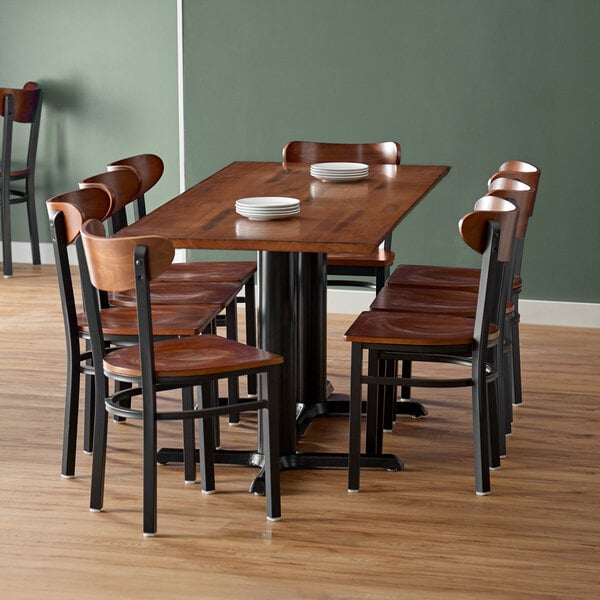 A Lancaster Table & Seating solid wood live edge dining table with chairs around it.
