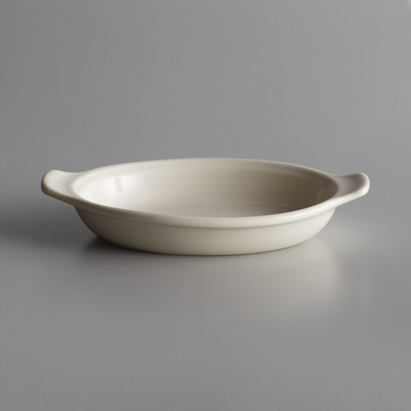 A Libbey Casablanca white porcelain rarebit dish with a handle on a gray surface.