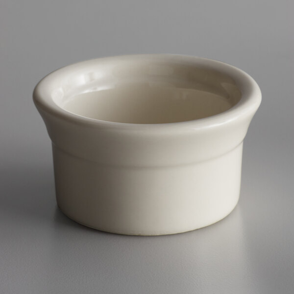 A white Libbey porcelain ramekin on a gray surface.