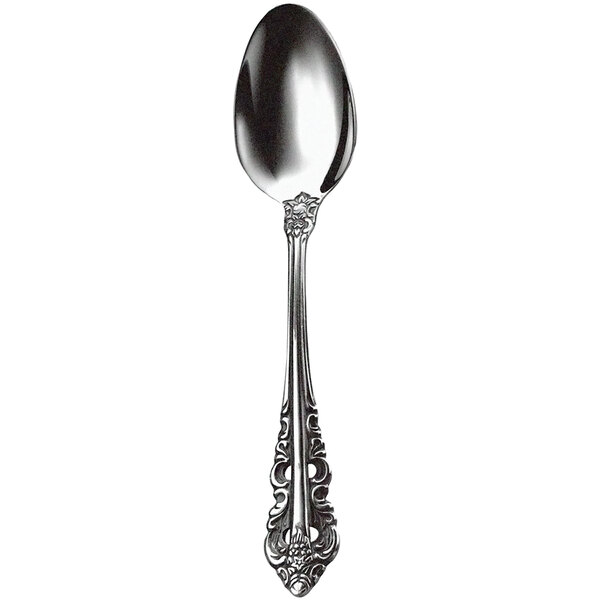 A close-up of a Walco stainless steel tea spoon with an ornate design.