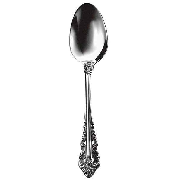A close-up of a Walco stainless steel dessert spoon with a Baroque style handle.