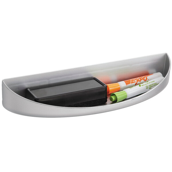 A silver metal Safco Rumba whiteboard eraser tray with markers and a black eraser inside.