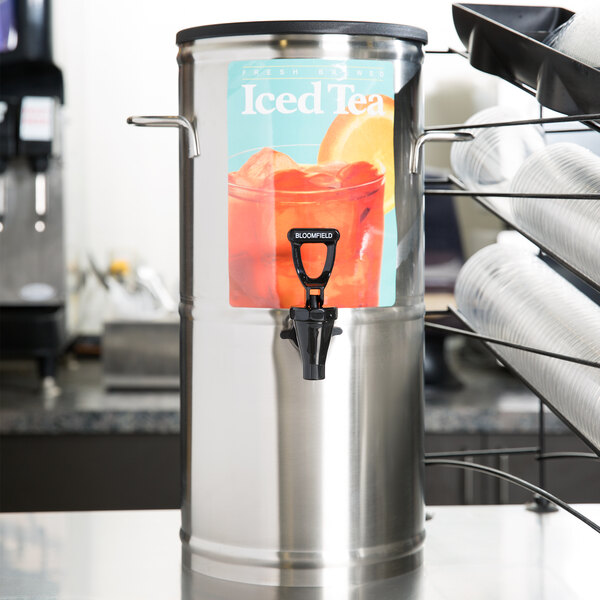 A stainless steel Bloomfield 3 gallon iced tea dispenser with a black handle.