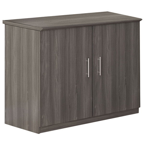 A gray steel Safco Medina storage cabinet with two doors and two drawers.