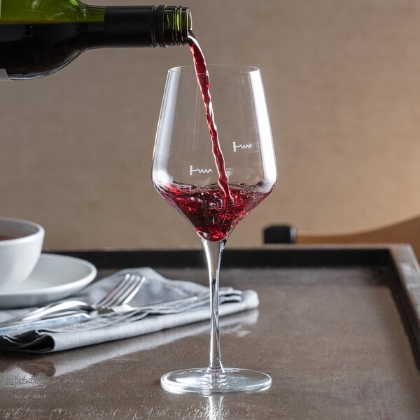 A Reserve by Libbey Acura Prism wine glass with red wine being poured into it.