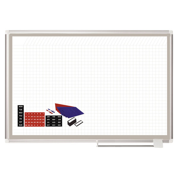 A white MasterVision planning board with grid lines, blue and red squares, and a triangle.