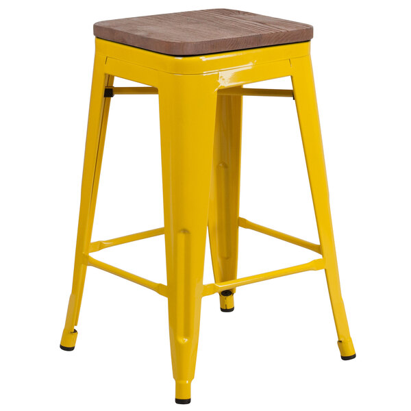 A yellow Flash Furniture metal backless counter height stool with a wooden seat.