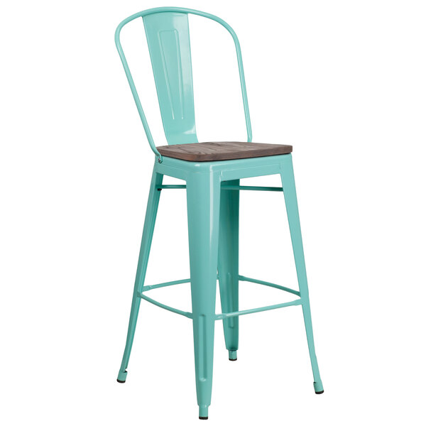 A mint green metal bar stool with a wooden seat.