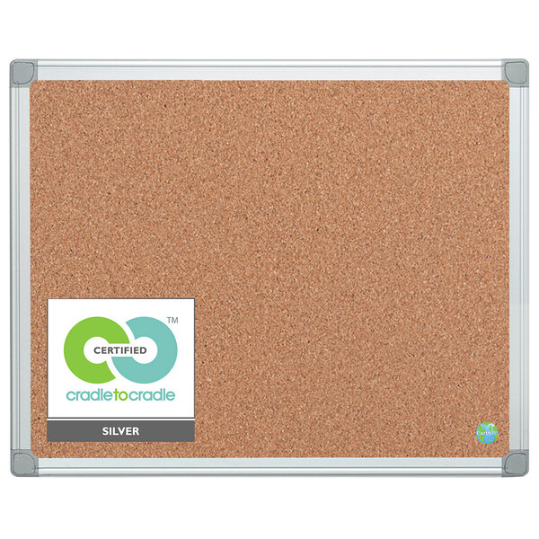 A cork board with a white frame and gray corners with a white label.