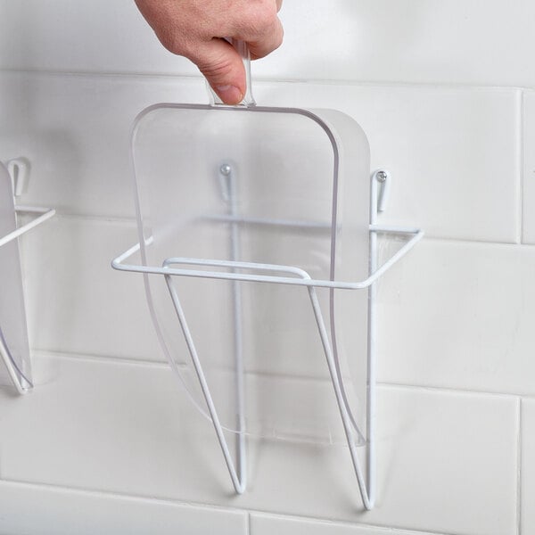 A hand using a Choice clear plastic utility scoop to fill a plastic container.