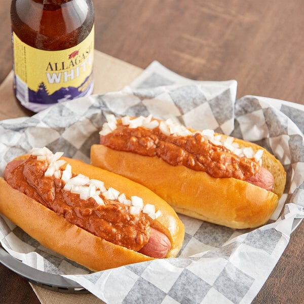 A hot dog with Vanee Chili Hot Dog Sauce and onions on a paper tray.