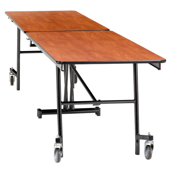 A National Public Seating rectangular cafeteria table with wheels on it.