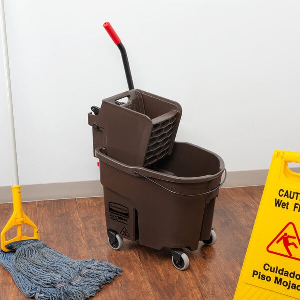 A Rubbermaid brown mop bucket with a side wringer.