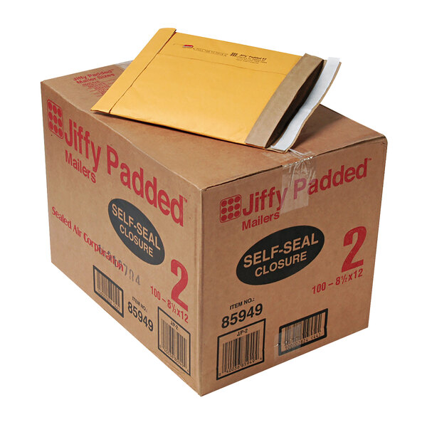 A brown box of Jiffy padded mailers with a yellow envelope on top.