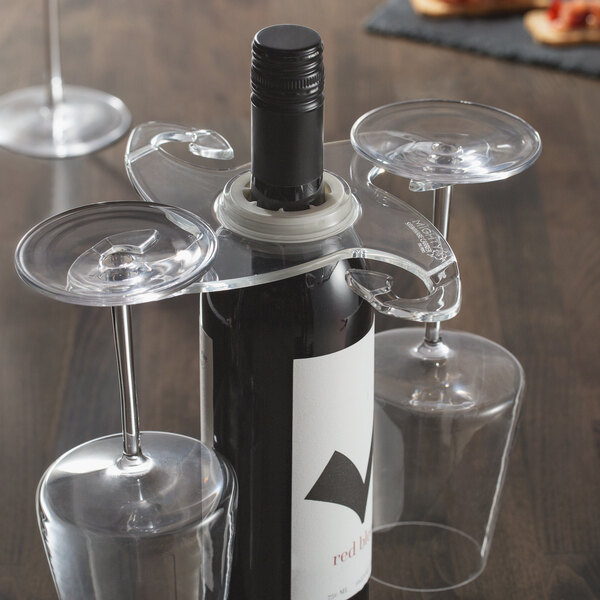 A Franmara wine bottle carrier with three wine glasses on top of a wine bottle on a table.