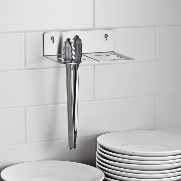 A stainless steel Edlund Smart Tong Holder on a white counter.