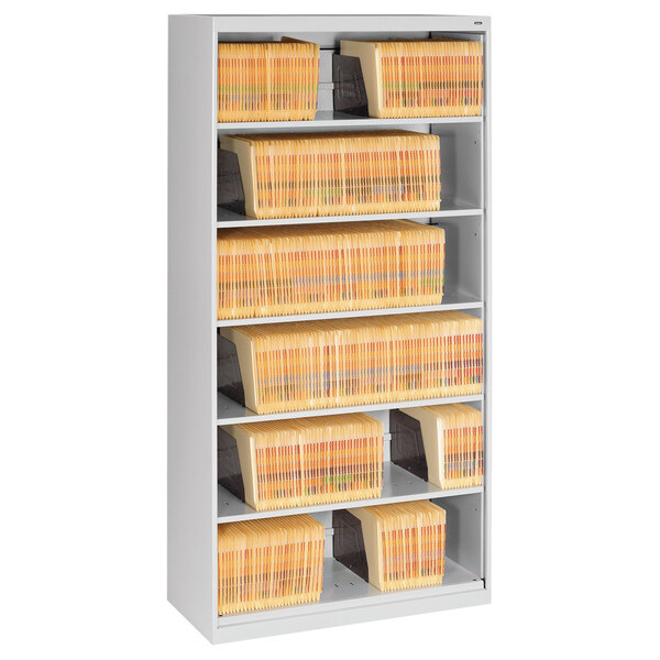 A Tennsco light gray lateral file cabinet with six shelves full of file folders.