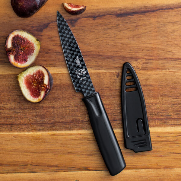 A black Mercer Culinary paring knife next to a cut fig.